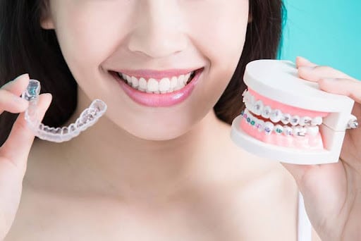 Woman showing different types of mouth braces for teeth