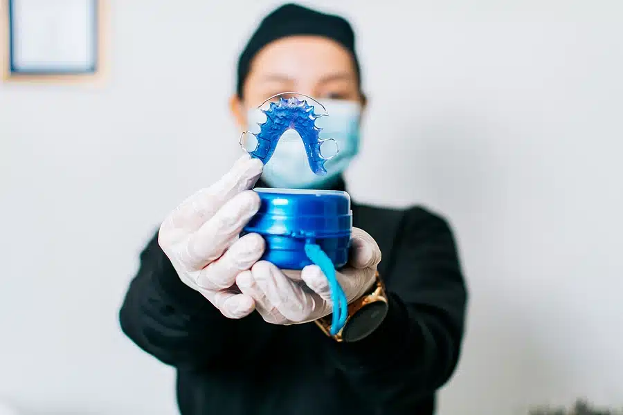 Female dentist holding dental retainers